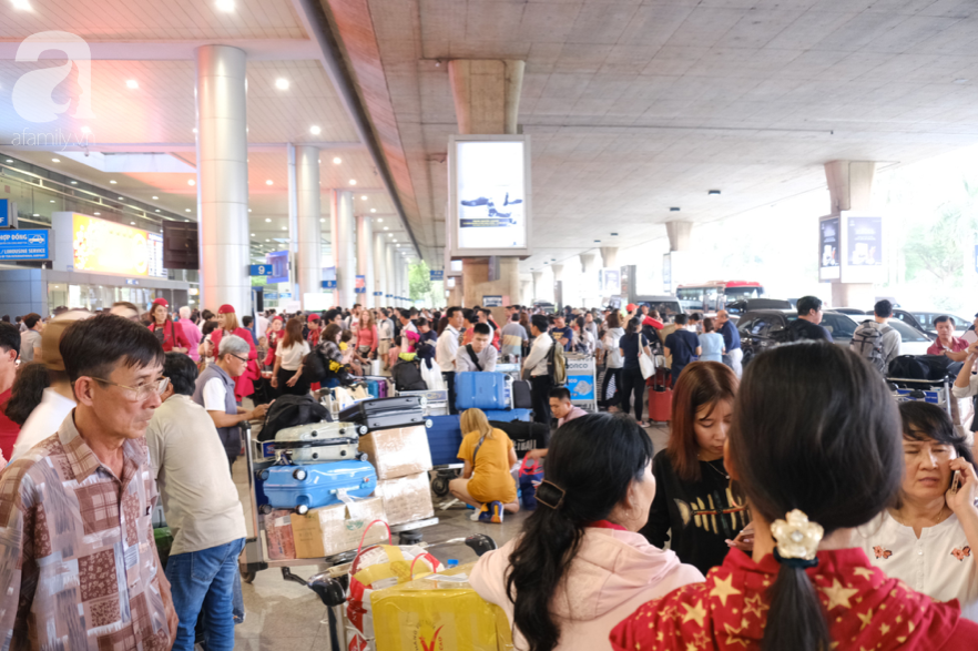 Sân bay Tân Sơn Nhất đông nghẹt: Trẻ em ngủ gục, người lớn cầm sẵn hoa chờ đón Việt kiều về nước ăn Tết - Ảnh 2.