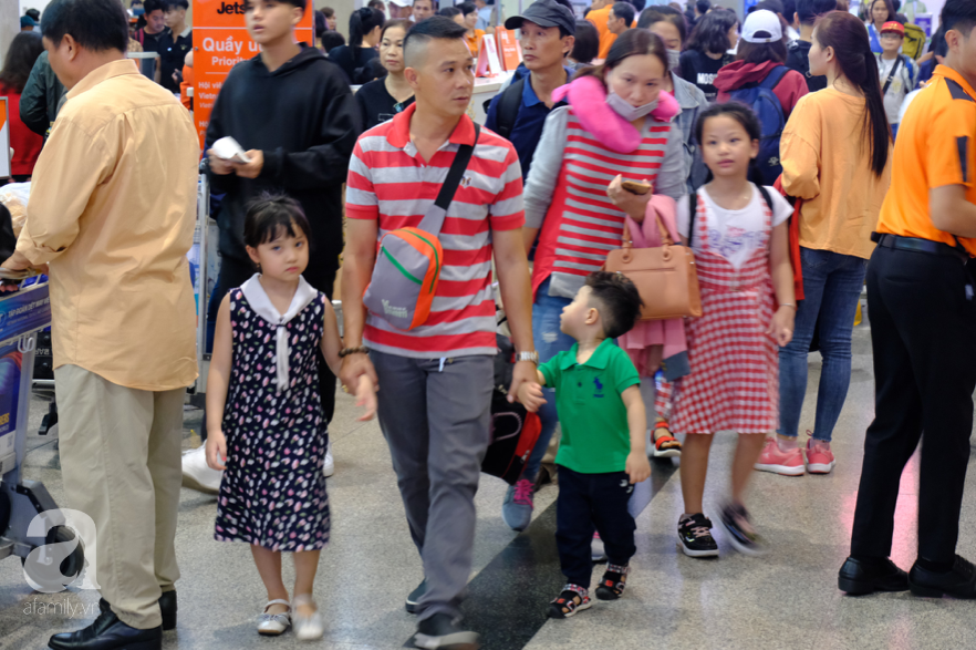Cận ngày giao thừa, sân bay Tân Sơn Nhất lại “vỡ trận”: Biển người chờ la liệt, trẻ mệt nhoài theo bố mẹ về quê - Ảnh 7.