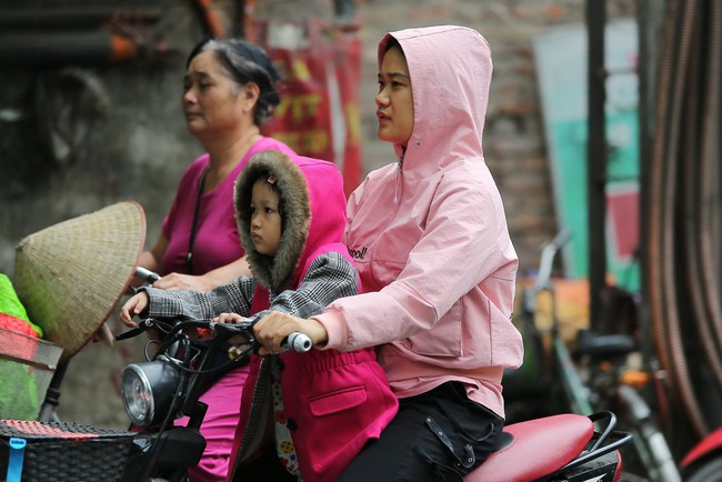Hà Nội: Không khí lạnh tràn về, nhiệt độ giảm mạnh, người dân co ro, mặc áo ấm khi ra đường - Ảnh 12. Hà Nội: Không khí lạnh tràn về, nhiệt độ giảm mạnh, người dân co ro, mặc áo ấm khi ra đường - Ảnh 12.
