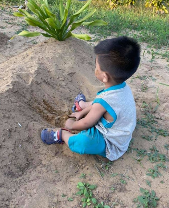 Chơi cát bên mộ bố mẹ và liên tục gọi "mẹ ơi", câu chuyện của cậu bé 2 tuổi đã lấy đi nước mắt của hàng ngàn người - Ảnh 1.