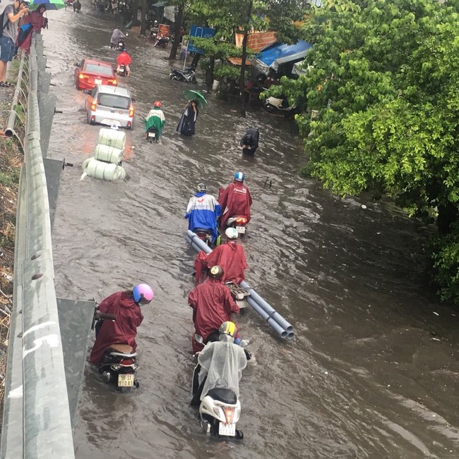 Mưa lớn kéo dài hơn 30 phút, người Sài Gòn bì bõm lội nước, té ngã vì nhiều tuyến đường ngập nặng - Ảnh 3.