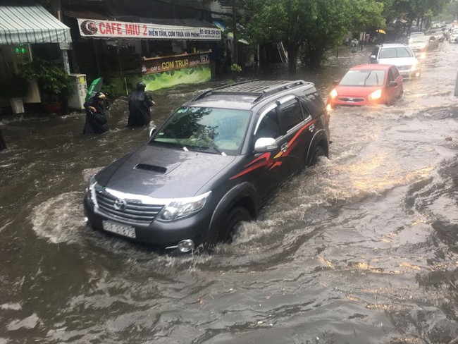 Mưa lớn kéo dài hơn 30 phút, người Sài Gòn bì bõm lội nước, té ngã vì nhiều tuyến đường ngập nặng - Ảnh 2.