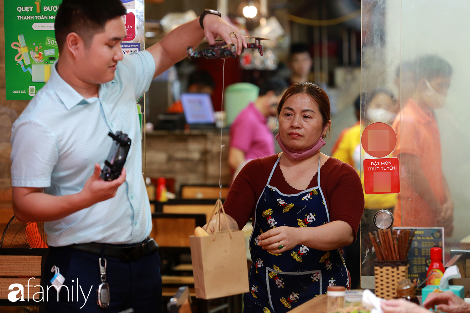 Trong thời kỳ dịch corona, ông chủ quán gây bất ngờ cho thực khách khi trổ tài làm &quot;phi công&quot; giao đồ ăn đến tận bàn bằng... flycam - Ảnh 1.