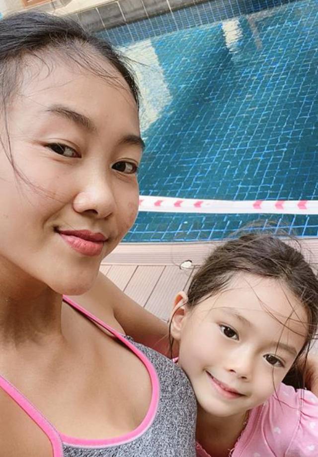 Đoan Trang tranh thủ chụp hình với con gái cưng bên bể bơi xanh trong.