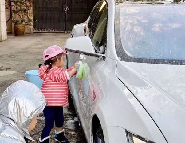 Bé gái đứng rửa xe ô tô bên đường để kiếm tiền, ai nấy rưng rưng thương cảm, đến khi biết sự thật thì mới choáng váng - Ảnh 1.