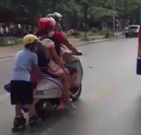 Người bố lái đèo theo 2 con nhỏ, để bé trai trượt patin bám vào đuôi xe trên đường đông đúc nhiều xe trọng tải lớn khiến người đi đường dựng tóc gáy - Ảnh 2. Người bố lái đèo theo 2 con nhỏ, để bé trai trượt patin bám vào đuôi xe trên đường đông đúc nhiều xe trọng tải lớn khiến người đi đường dựng tóc gáy - Ảnh 2.