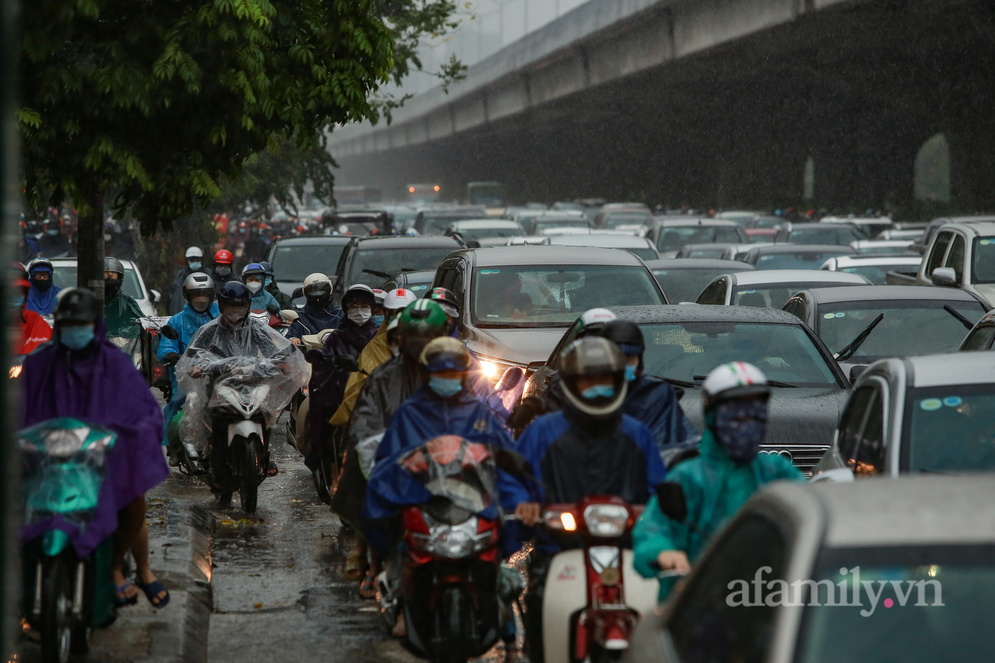 Đường phố ùn tắc, người Hà Nội vật lộn đi làm trong cơn mưa tầm tã - Ảnh 4.