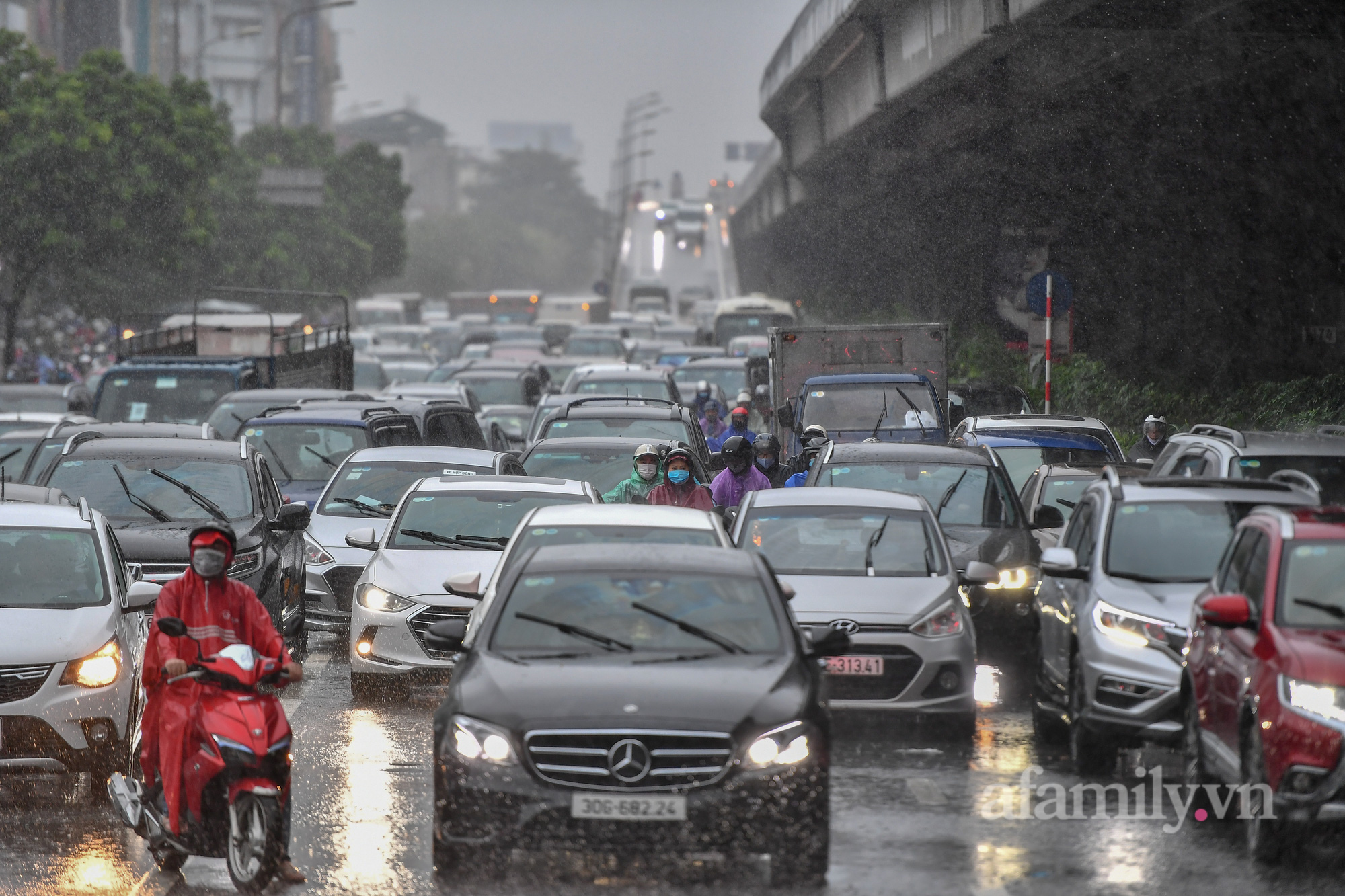 Đường phố ùn tắc, người Hà Nội vật lộn đi làm trong cơn mưa tầm tã - Ảnh 10.