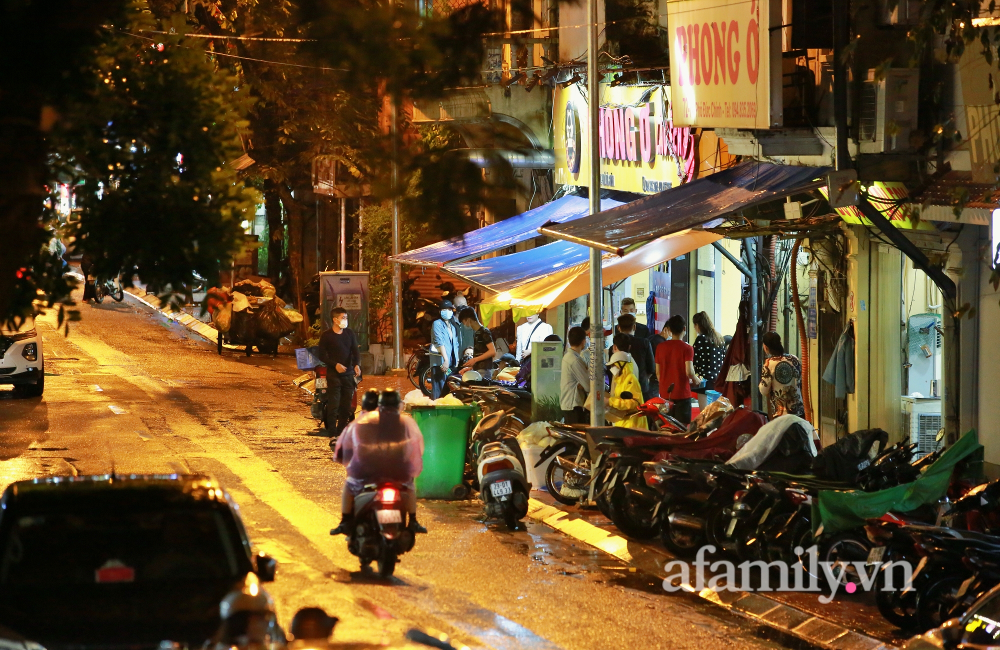 Hà Nội tối đầu tiên &quot;bình thường mới&quot;: Quán lẩu đông khách đội mưa xếp hàng, nộm bò khô không ai ngó ngàng - Ảnh 1.