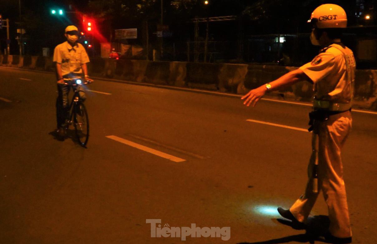 Hàng loạt người đạp xe tập thể dục buổi sáng vượt đèn đỏ bị CSGT phạt - Ảnh 1.
