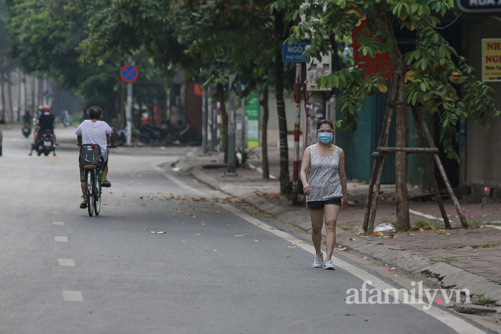 Hà Nội ngày thứ 17 giãn cách xã hội, nhiều người dân vẫn ra đường tập thể dục buổi sáng, có người treo quả bí đỏ trước xe để đạp xe đạp - Ảnh 1.