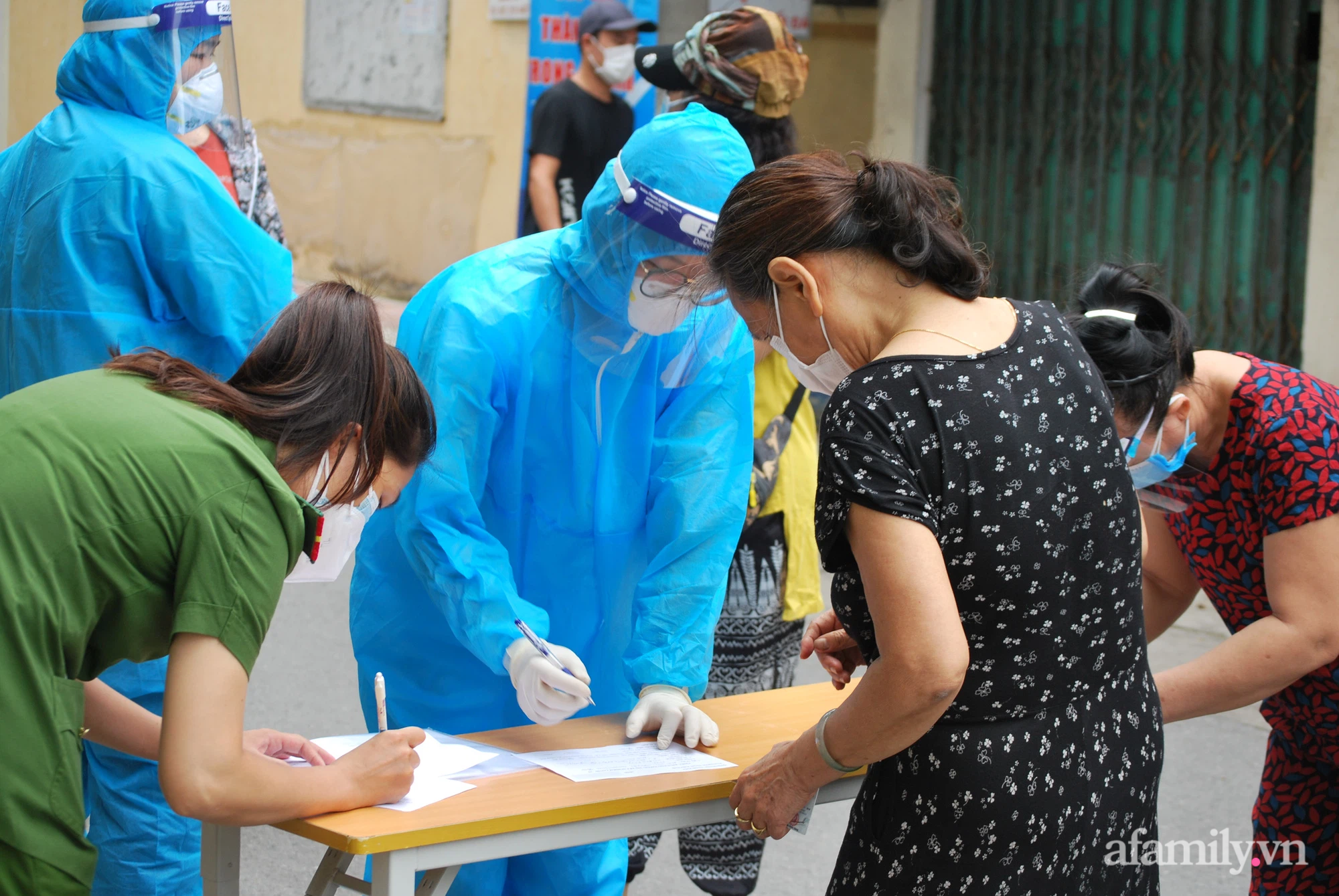 Nhân việ y tế hướng dẫn người dân khai báo y tế trước khi lấy mẫu