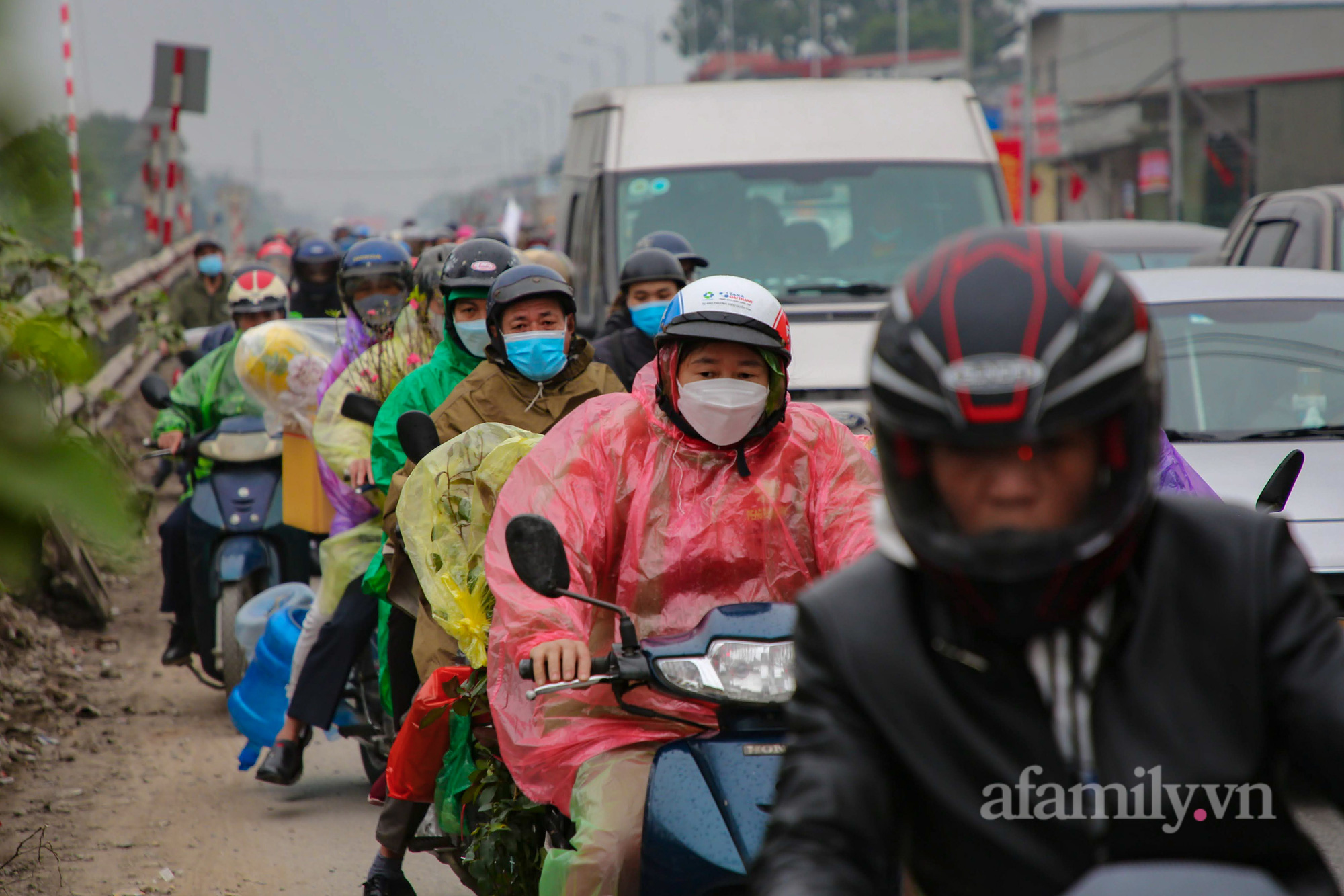Hà Nội: Hàng nghìn người chạy xe máy trùm kín áo mưa, ùn ùn rời phố về quê ăn Tết - Ảnh 10.