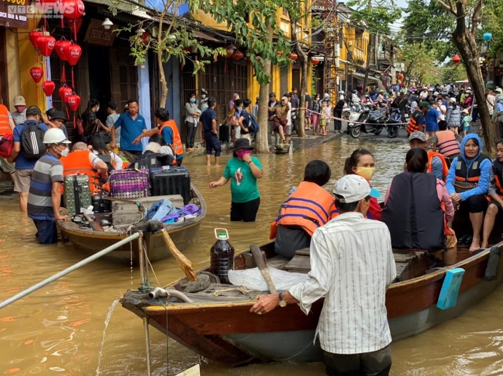 Kiếm bộn tiền nhờ chèo thuyền rước khách tham quan phố cổ Hội An ngập lụt - Ảnh 3.