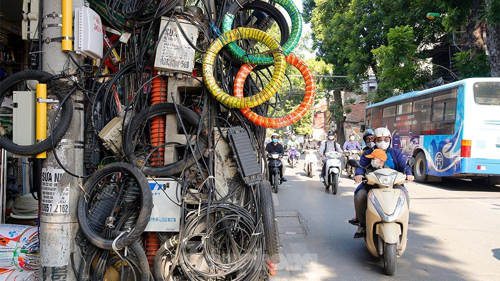 Dây điện, dây viễn thông chằng chịt như mạng nhện khắp phố phường, 'bẫy' người đi đường Hà Nội - Ảnh 1. Dây điện, dây viễn thông chằng chịt như mạng nhện khắp phố phường, 'bẫy' người đi đường Hà Nội - Ảnh 1.