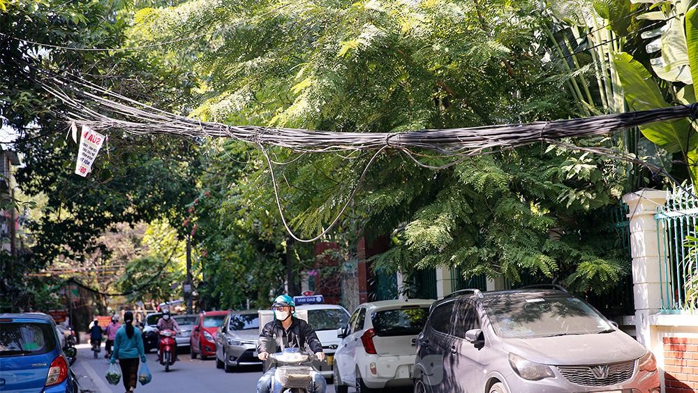 Dây điện, dây viễn thông chằng chịt như mạng nhện khắp phố phường, 'bẫy' người đi đường Hà Nội - Ảnh 3. Dây điện, dây viễn thông chằng chịt như mạng nhện khắp phố phường, 'bẫy' người đi đường Hà Nội - Ảnh 3.