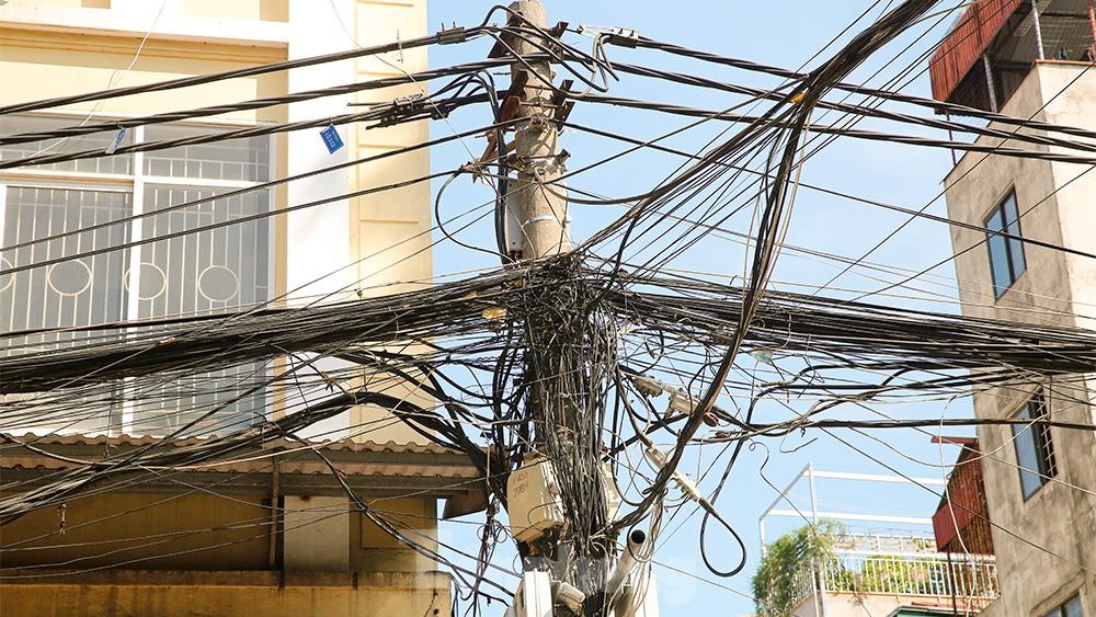 Dây điện, dây viễn thông chằng chịt như mạng nhện khắp phố phường, 'bẫy' người đi đường Hà Nội - Ảnh 5. Dây điện, dây viễn thông chằng chịt như mạng nhện khắp phố phường, 'bẫy' người đi đường Hà Nội - Ảnh 5.