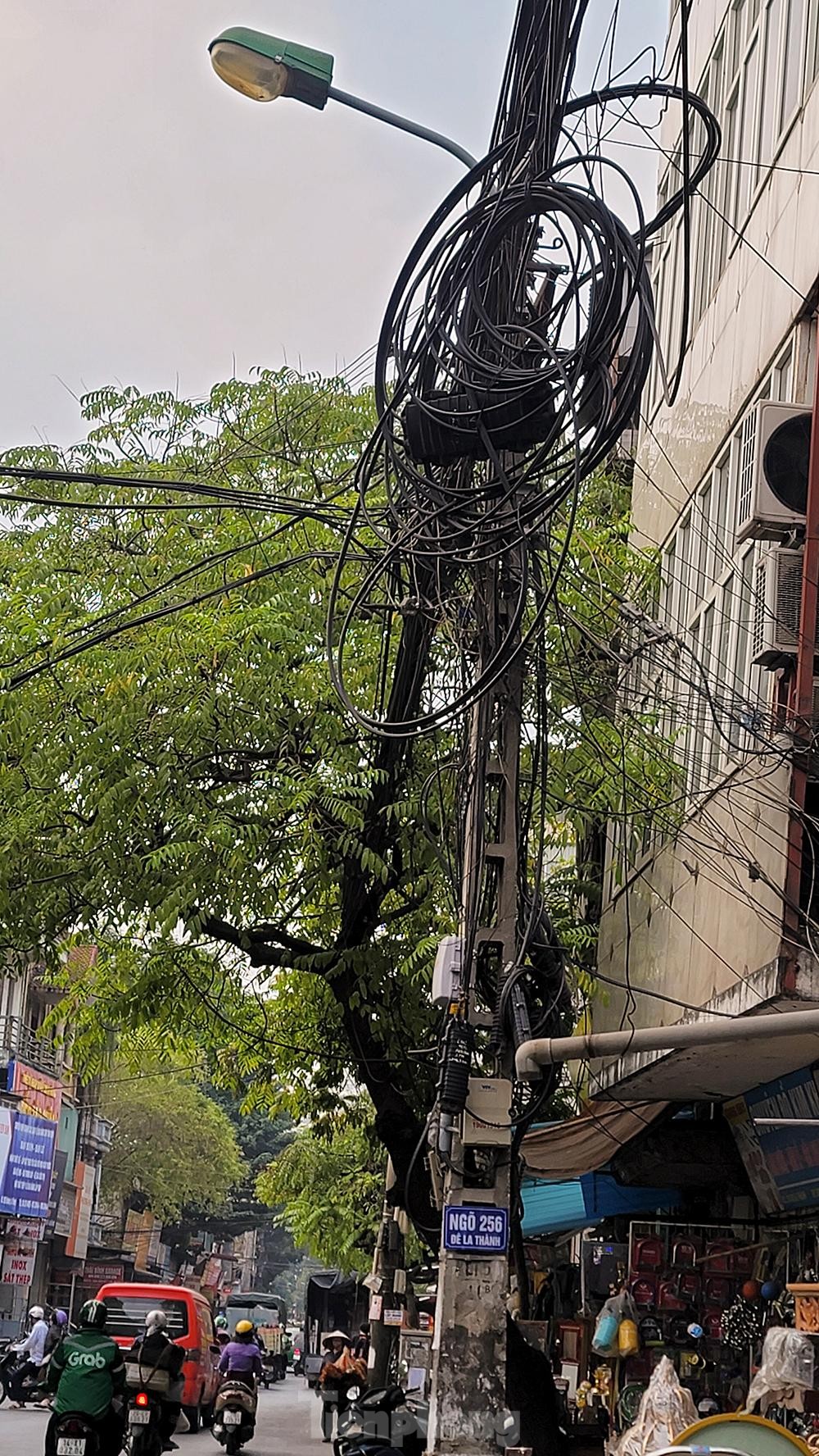 Dây điện, dây viễn thông chằng chịt như mạng nhện khắp phố phường, 'bẫy' người đi đường Hà Nội - Ảnh 11. Dây điện, dây viễn thông chằng chịt như mạng nhện khắp phố phường, 'bẫy' người đi đường Hà Nội - Ảnh 11.