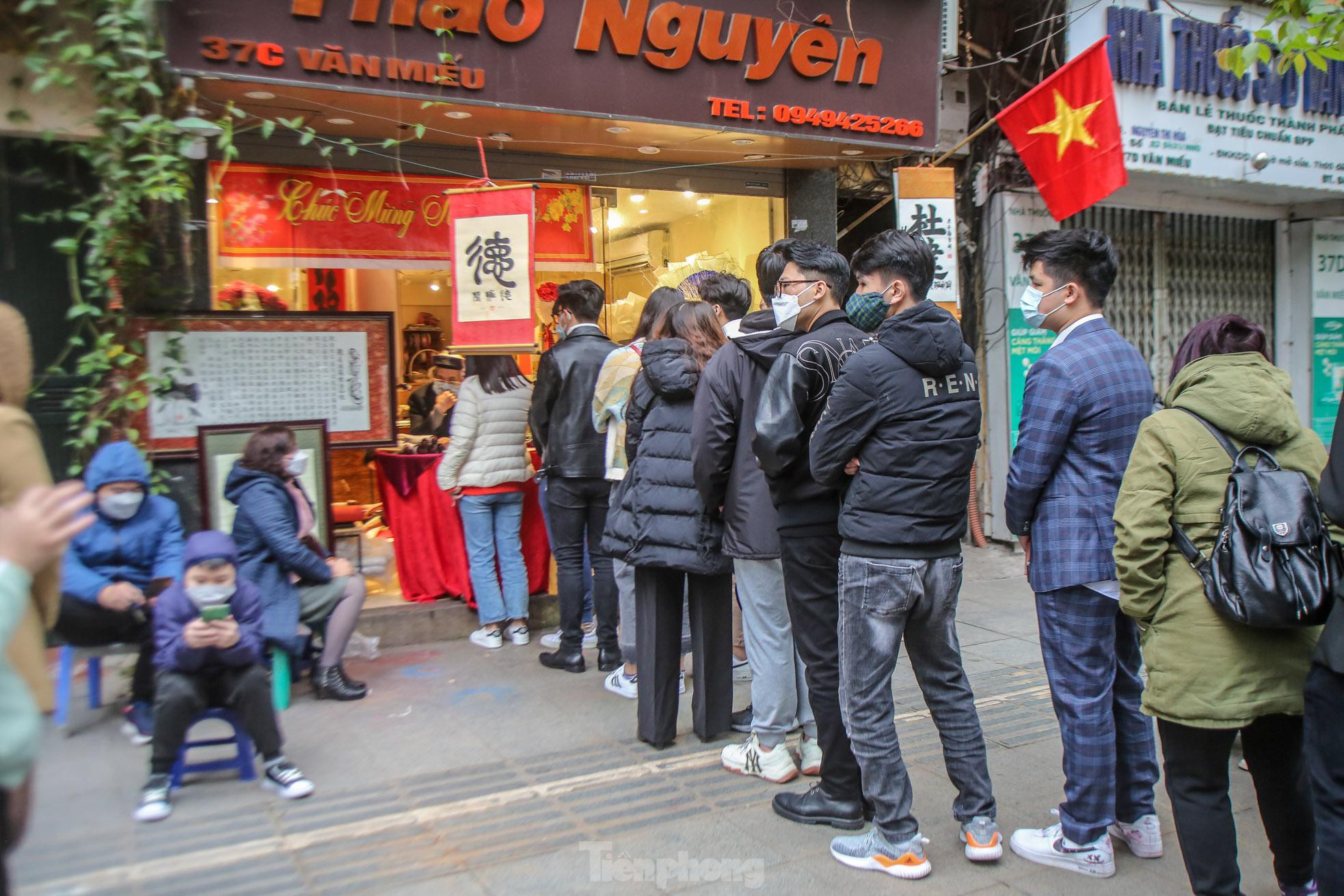 Sĩ tử xếp hàng 'vái vọng', xin chữ đầu năm bên ngoài Văn Miếu - Ảnh 5. Sĩ tử xếp hàng 'vái vọng', xin chữ đầu năm bên ngoài Văn Miếu - Ảnh 5.