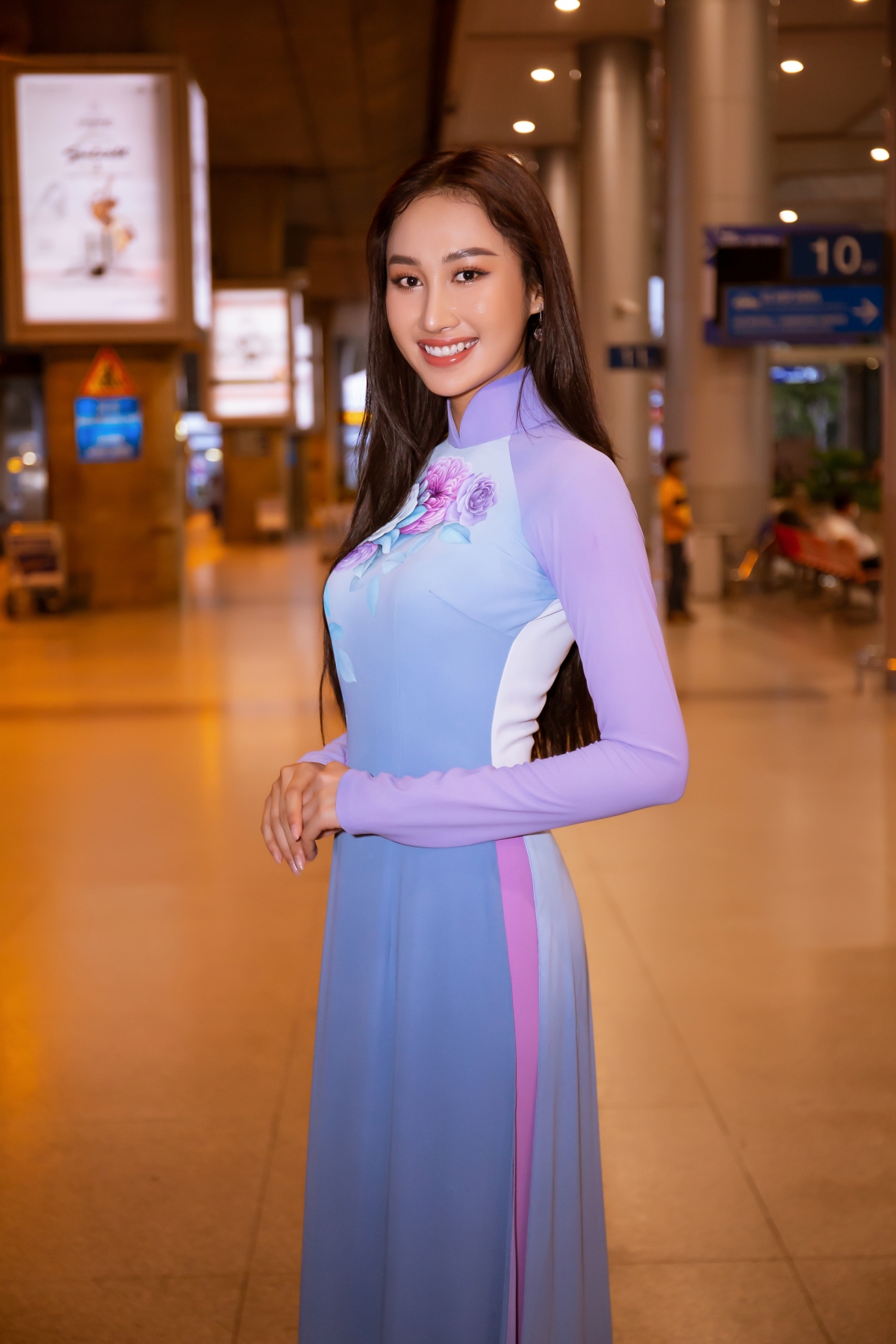 Đoàn Hồng Trang diện áo dài lụa ra sân bay đón Miss Global 2019 đến Việt Nam - Ảnh 1.