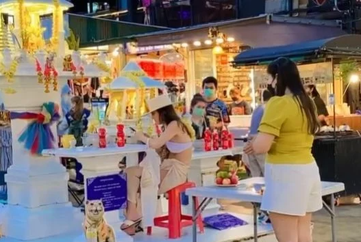 Image cut from video. Casually using the local altar as a resting table, Thai tourists are not condemned, on the contrary, they are sympathized