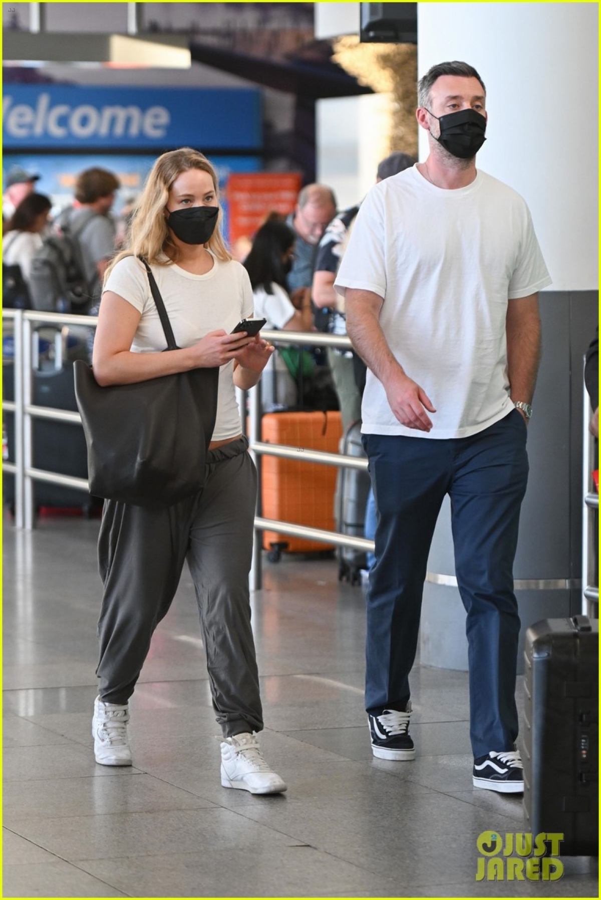 Vợ chồng Jennifer Lawrence lên đồ đồng điệu tái xuất ở sân bay - Ảnh 1.
