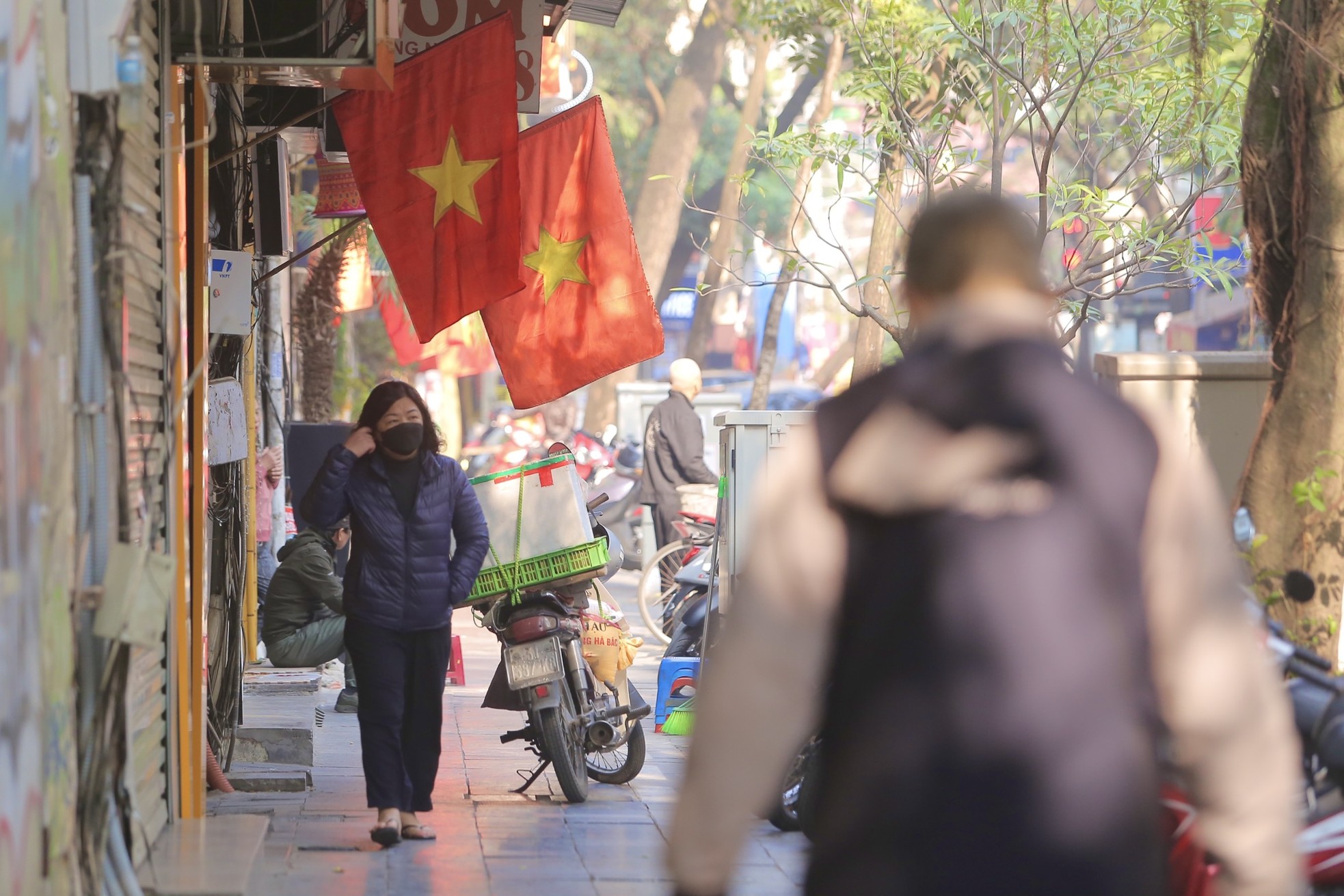 Phố phường Hà Nội đỏ thắm màu cờ ngày 30 Tết - Ảnh 1.