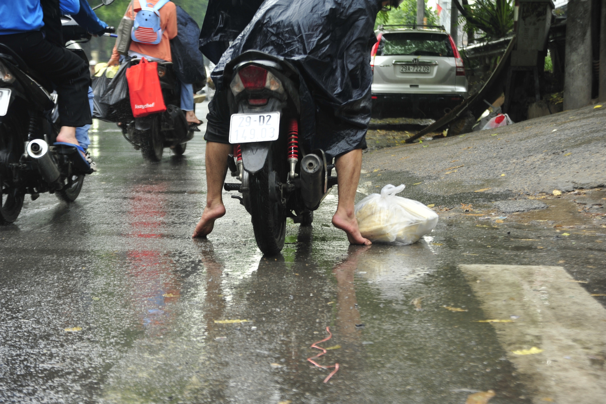 Gặp cơn mưa bất ngờ nam thanh niên này chọn phương án cởi giầy cất vào cốp xe
