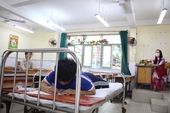 Nam sinh TP.HCM được đặc c&aacute;ch nằm l&agrave;m b&agrave;i thi tốt nghiệp - Ảnh 1.