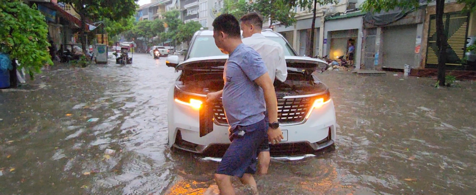 Bất lực đẩy ô tô chết máy giữa đường do ngập sau mưa lớn ở Hà Nội - Ảnh 1.