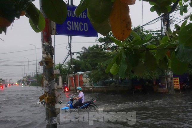 Mưa trắng trời, người dân TPHCM xách dép lội bì bõm trên quốc lộ - Ảnh 2.