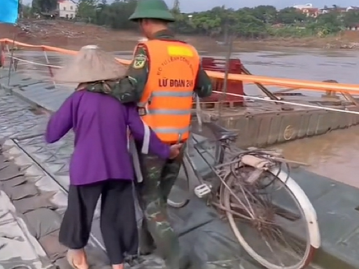 Ấm lòng cảnh anh bộ đội dắt hộ xe đạp, dìu cụ bà qua cầu phao Phong Châu - Ảnh 1.