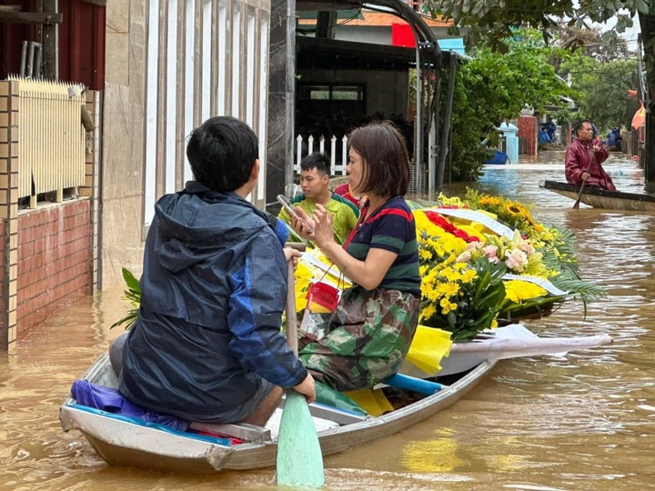 Quặn lòng cảnh chèo thuyền vượt lũ đưa người thân đi mai táng ở Quảng Bình - Ảnh 1.