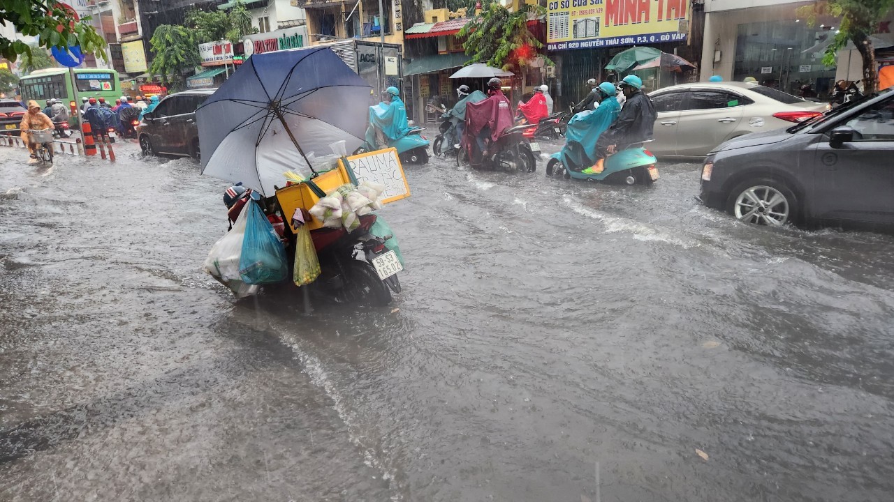 Mưa trắng trời ở TPHCM, giao lộ dẫn vào sân bay Tân Sơn Nhất ngập chưa từng thấy - Ảnh 4.