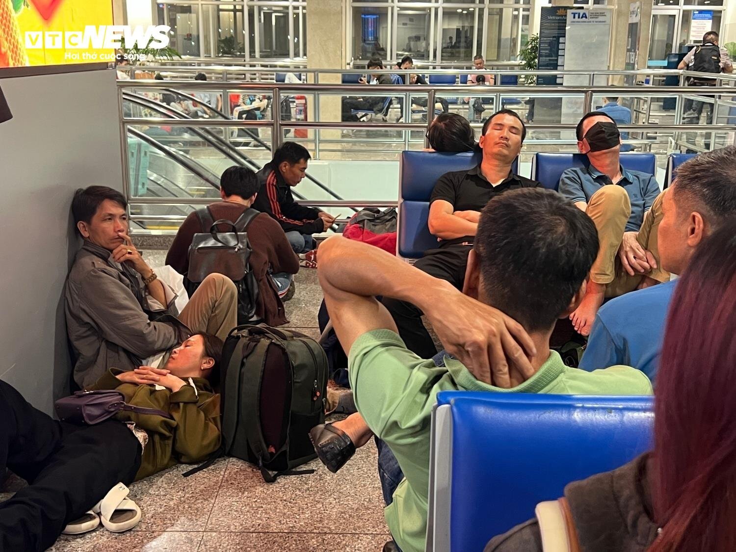 Khách nằm, ngồi la liệt ở sân bay Tân Sơn Nhất ngày 27 Tết - Ảnh 2.