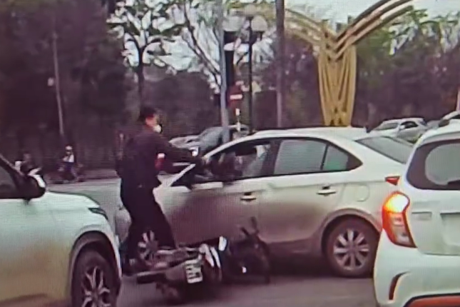 Va chạm giao thông, người đàn ông dùng mũ bảo hiểm đập vỡ kính ô tô - Ảnh 2.
