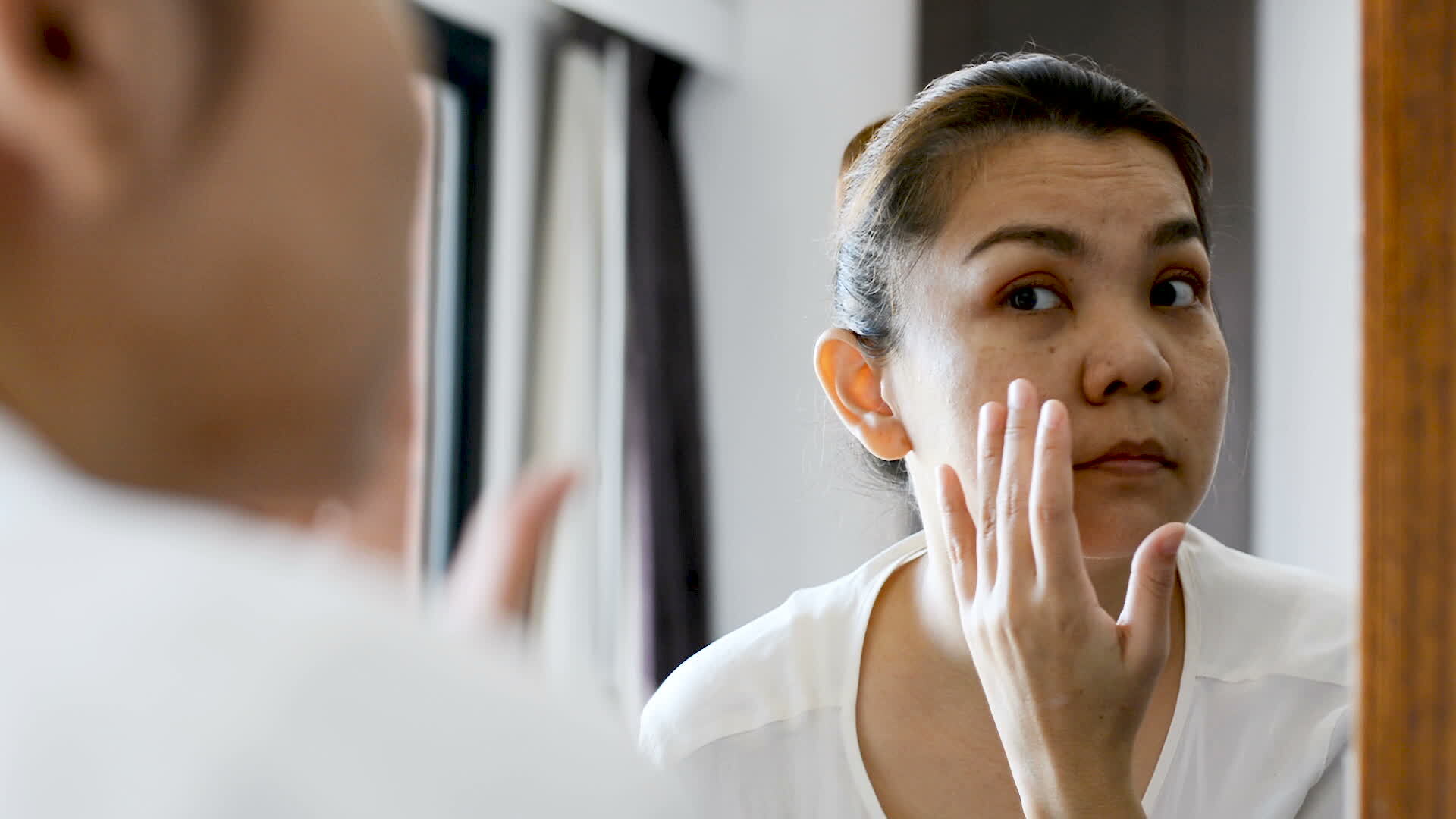 middle-aged-asian-woman-looking-at-wrinkles-in-mirror-17186259199631218121971-1718626491913-17186264920441366684121.jpg