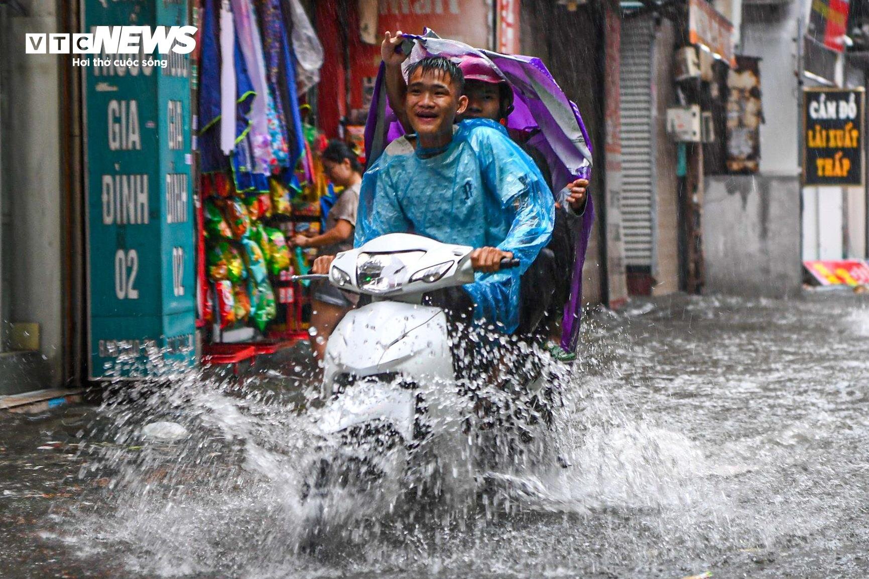 Hà Nội mưa từ sáng đến chiều, xe cộ bì bõm &quot;bơi&quot; trên đường - Ảnh 7.