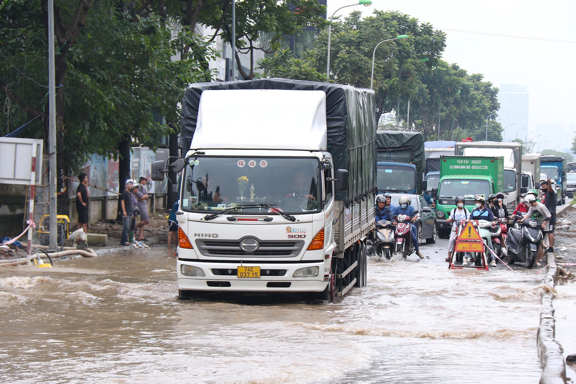 Đại lộ Thăng Long ùn tắc vì ngập, dịch vụ xe kéo đắt khách - Ảnh 2.