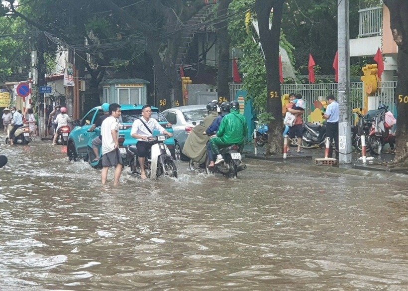 Trường học ở Hà Nội bất ngờ ngập sau trận mưa đêm, phụ huynh chật vật đưa con đến lớp - Ảnh 2.