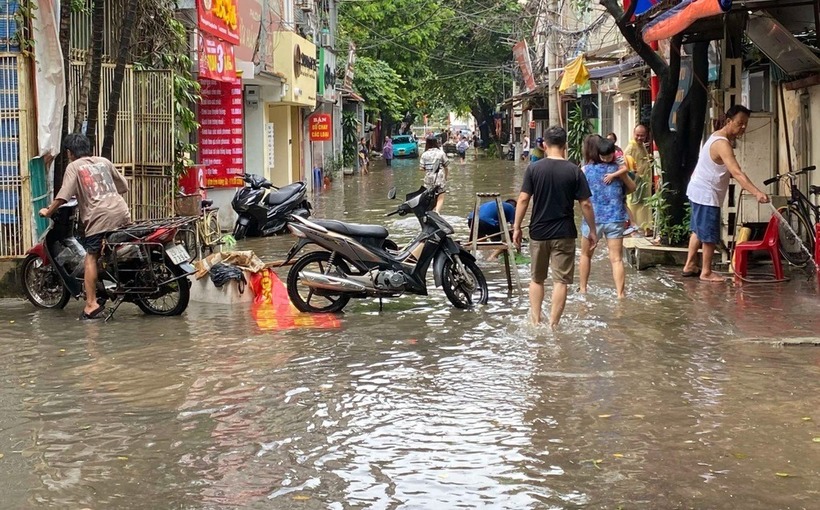 Trường học ở Hà Nội bất ngờ ngập sau trận mưa đêm, phụ huynh chật vật đưa con đến lớp - Ảnh 3.