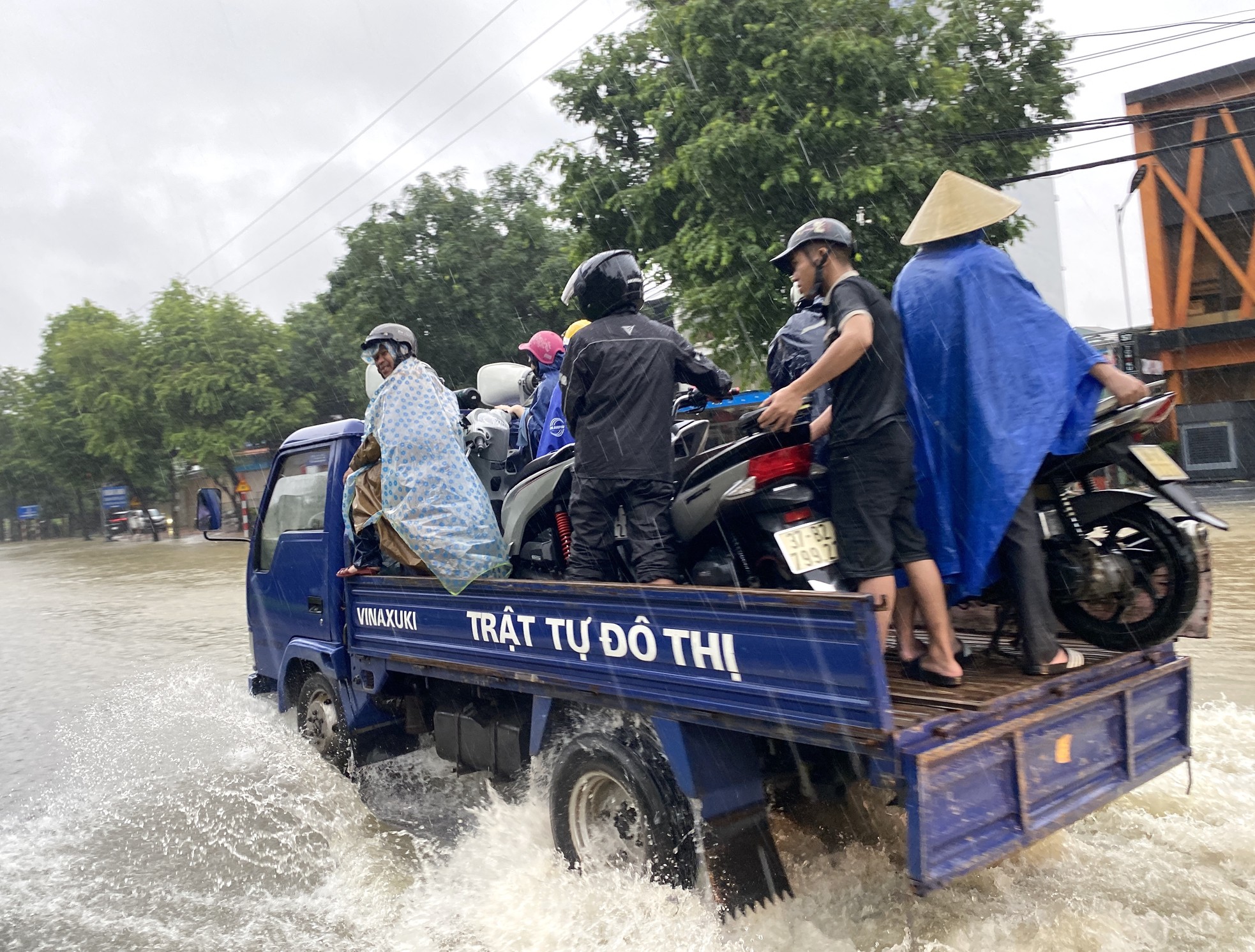 Đường ngập sâu, dân bì bõm mang thùng xốp làm thuyền kéo đồ trên phố- Ảnh 4.