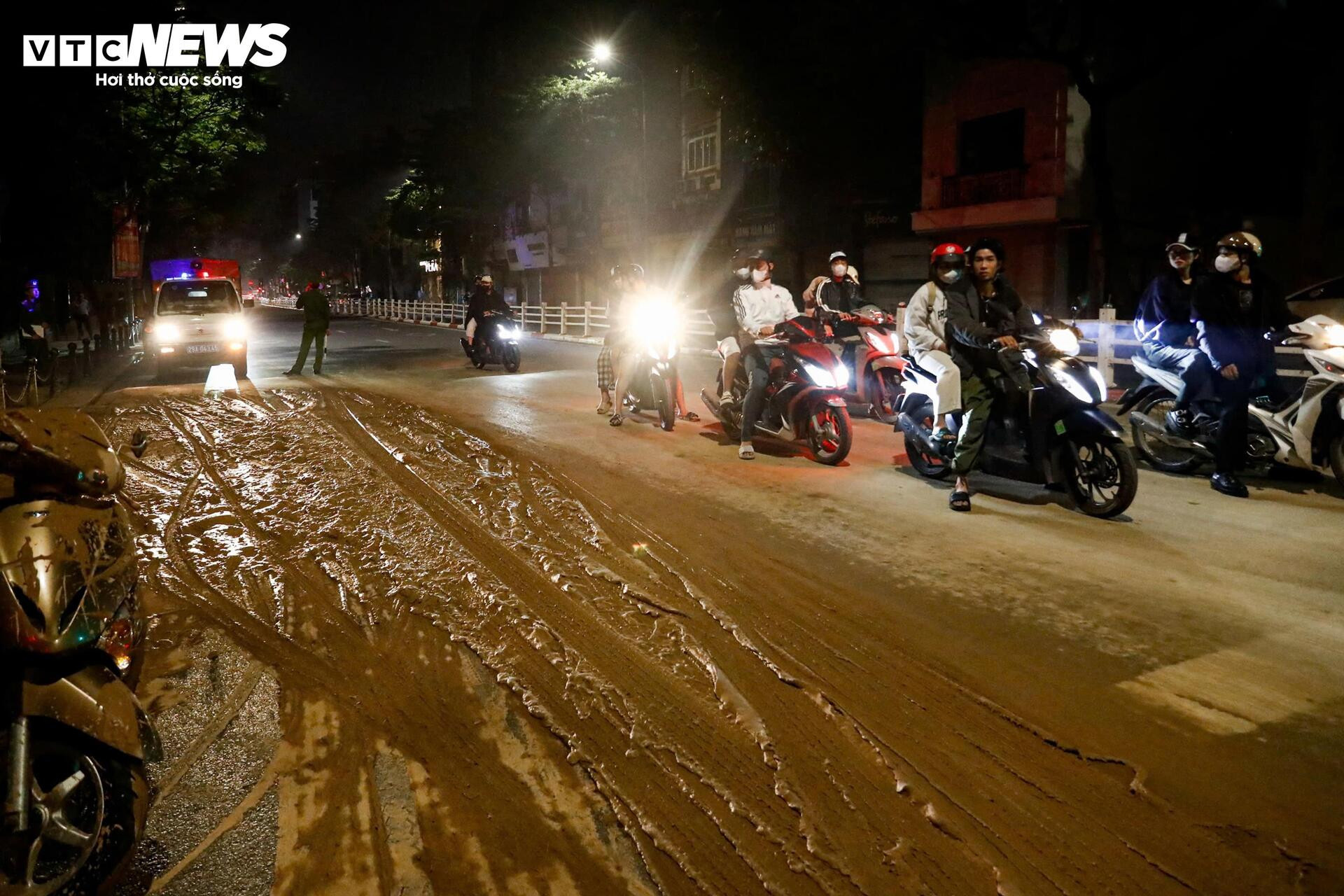 Bùn nhão tràn khắp đường, hàng loạt xe máy ngã sõng soài ở Hà Nội - Ảnh 1.
