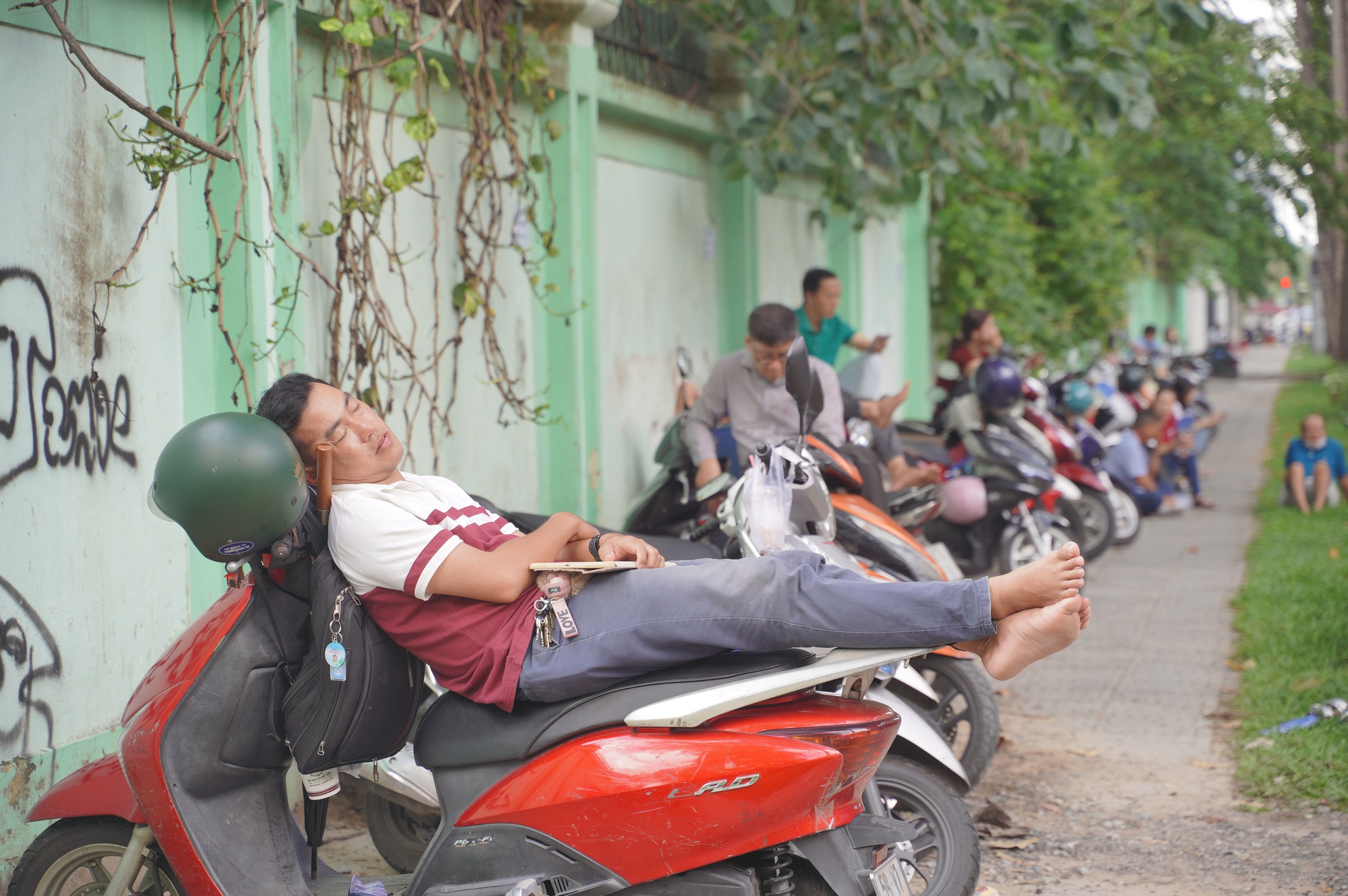 CẬP NHẬT: Thí sinh làm bài thi môn Văn, phụ huynh tranh thủ chợp mắt trên xe máy chờ con- Ảnh 6. CẬP NHẬT: Thí sinh làm bài thi môn Văn, phụ huynh tranh thủ chợp mắt trên xe máy chờ con- Ảnh 6.