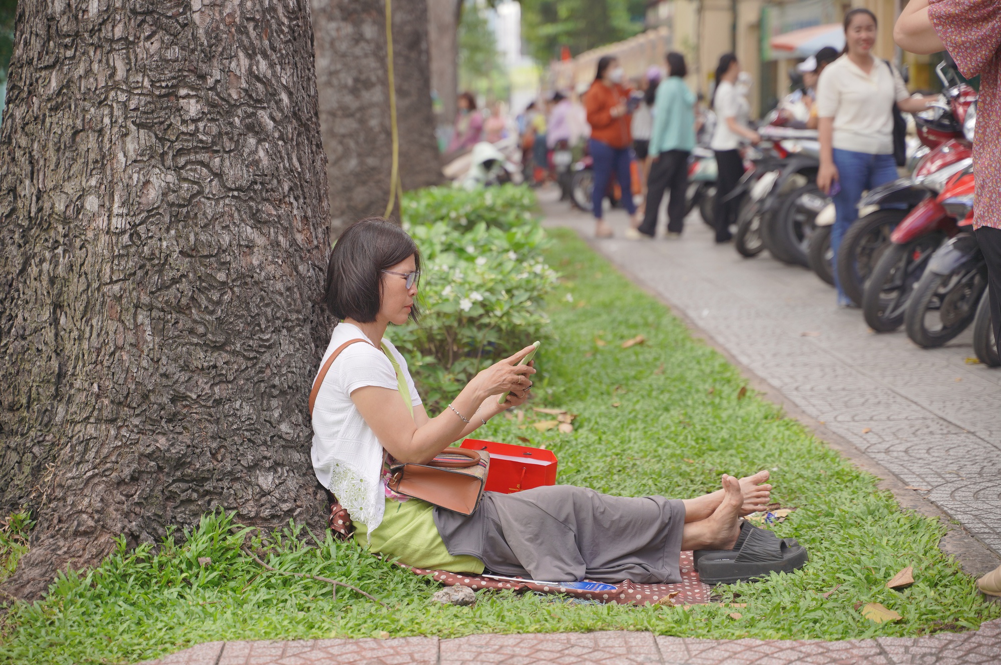 CẬP NHẬT: Thí sinh làm bài thi môn Văn, phụ huynh tranh thủ chợp mắt trên xe máy chờ con- Ảnh 1. CẬP NHẬT: Thí sinh làm bài thi môn Văn, phụ huynh tranh thủ chợp mắt trên xe máy chờ con- Ảnh 1.