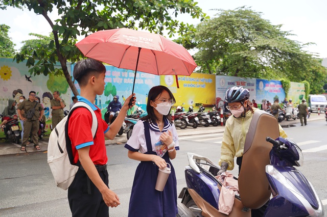 Thi vào lớp 10 TP.HCM buổi thứ 2: Vừa mưa xong nhưng vẫn oi nóng, sĩ tử được TNV che ô đón vào điểm thi - Ảnh 1. Thi vào lớp 10 TP.HCM buổi thứ 2: Vừa mưa xong nhưng vẫn oi nóng, sĩ tử được TNV che ô đón vào điểm thi - Ảnh 1.