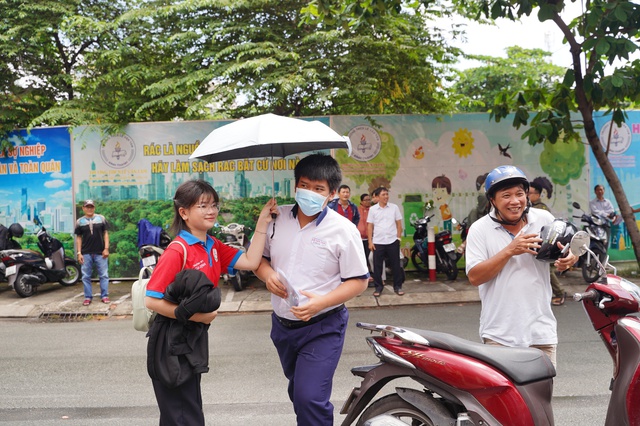 Thi vào lớp 10 TP.HCM buổi thứ 2: Vừa mưa xong nhưng vẫn oi nóng, sĩ tử được TNV che ô đón vào điểm thi - Ảnh 3. Thi vào lớp 10 TP.HCM buổi thứ 2: Vừa mưa xong nhưng vẫn oi nóng, sĩ tử được TNV che ô đón vào điểm thi - Ảnh 3.