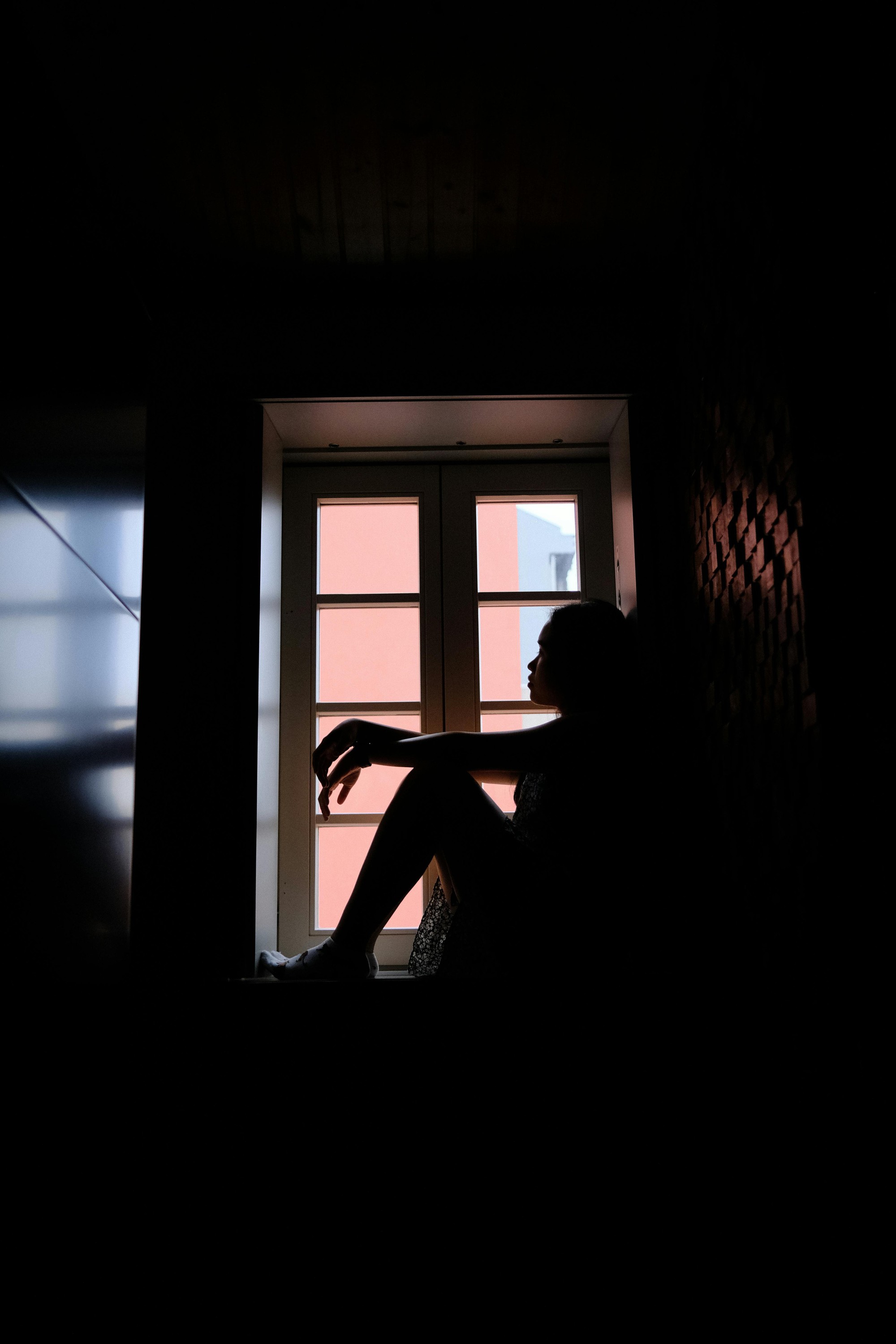 free-photo-of-woman-sitting-on-windowsill-in-dark-room-17540330011981864291081-1754060951799-17540609519971933311483.jpeg
