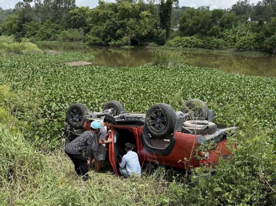 Xe bán tải do người phụ nữ mang thai điều khiển tông hàng loạt cọc tiêu rồi lao xuống sông - Ảnh 1. Xe bán tải do người phụ nữ mang thai điều khiển bất ngờ lao xuống sông - Ảnh 1.
