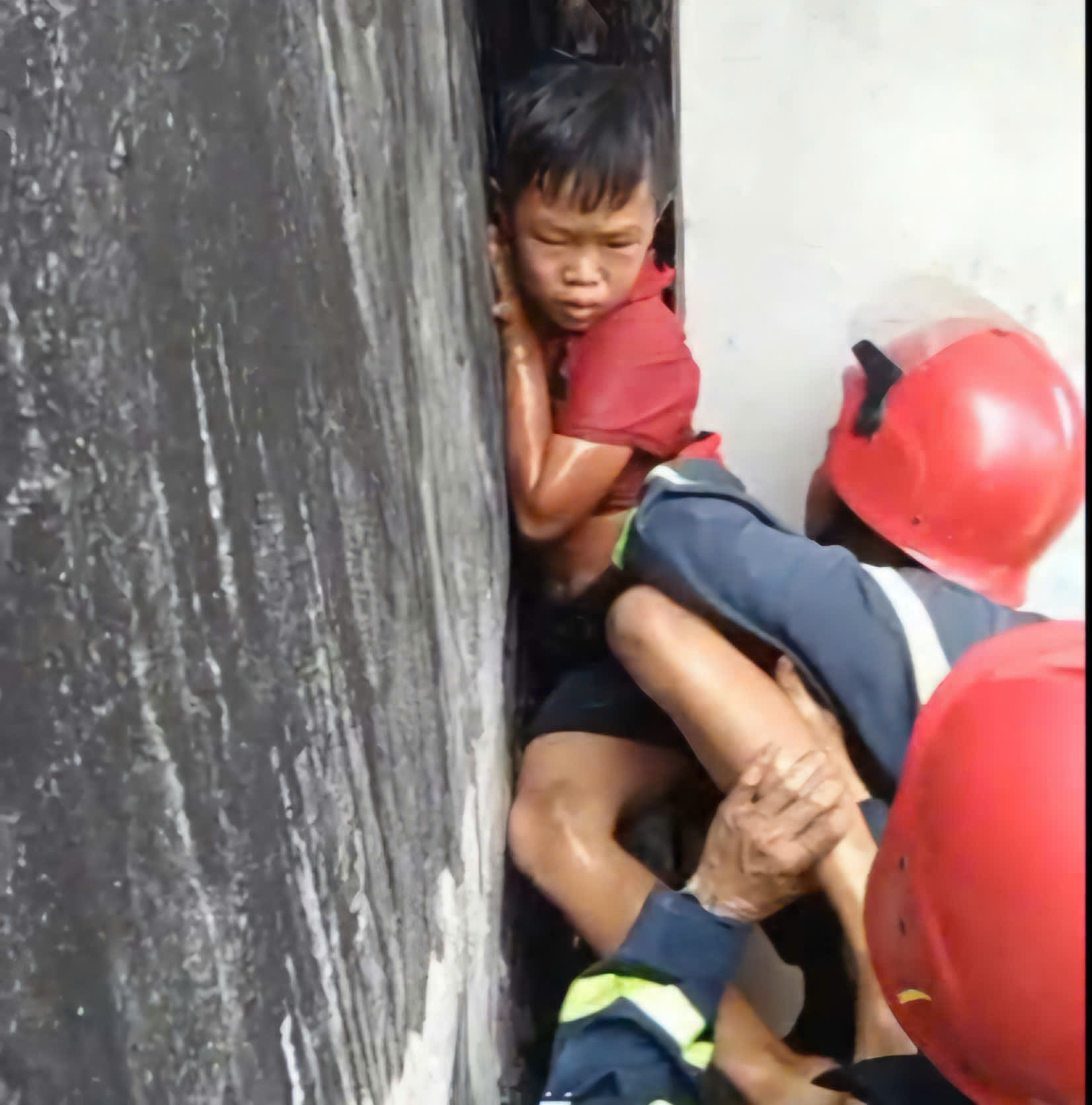Giải cứu b&eacute; trai mắc kẹt giữa hai bức tường khi leo m&aacute;i nh&agrave; bắt m&egrave;o - Ảnh 2.